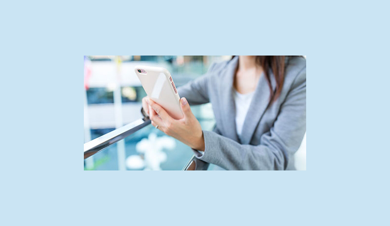 Business_woman_holding_phone_outdoors-2.jpg